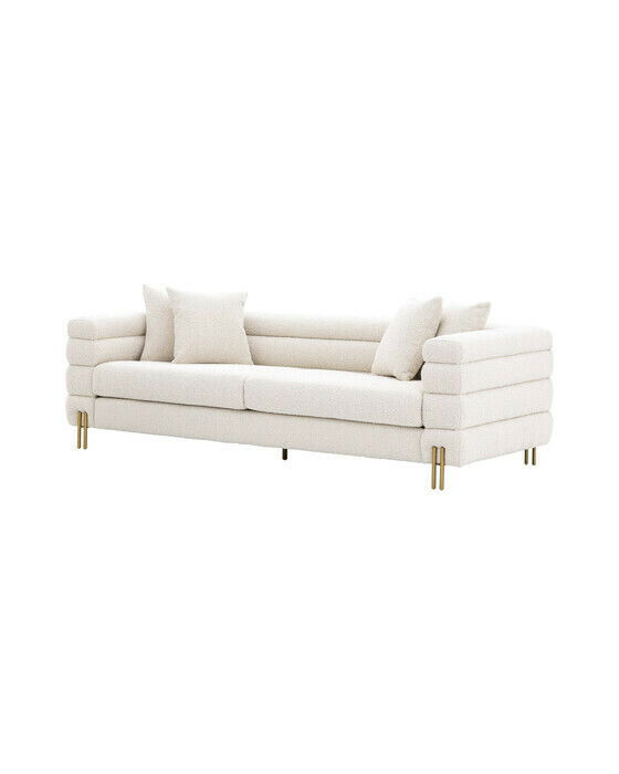 Kremfarget sofa i bouclé-stoff med en rund, myk form inspirert av art deco
